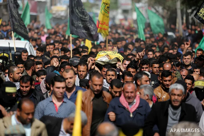 Palestinians carry the body of Hamdan Abu Amsha who was killed a day earlier during clashes with Israeli security forces in a tent city protest along the Israel border with Gaza, demanding the right to return to their ho...