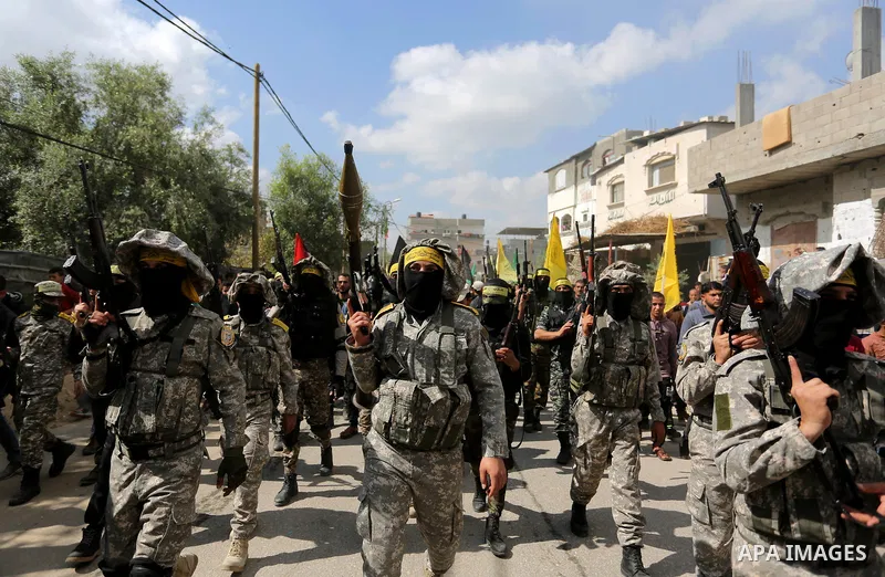 Palestinian militants of Al-Aqsa Martyrs' Brigades attend a funeral of Hamdan Abu Amsha who was killed a day earlier during clashes with Israeli security forces in a tent city protest along the Israel border with Gaza, d...
