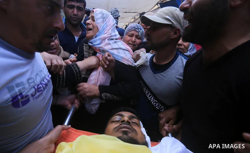 Palestinians carry the body of Jihad Abu Jamous who was killed a day earlier during clashes with Israeli security forces in a tent city protest along the Israel border with Gaza, demanding the right to return to their ho...