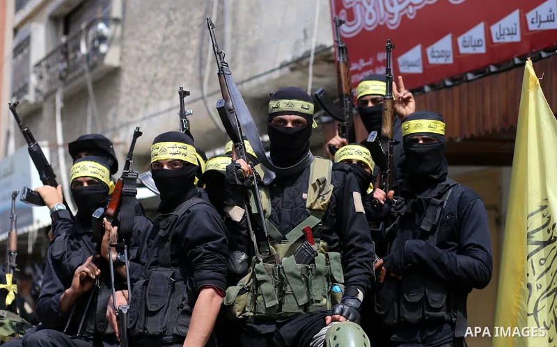 Palestinian militants of Al-Aqsa Martyrs' Brigades attend a funeral of Jihad Abu Jamous who was killed a day earlier during clashes with Israeli security forces in a tent city protest along the Israel border with Gaza, d...