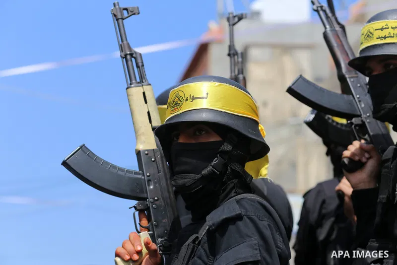 Palestinian militants of Al-Aqsa Martyrs' Brigades attend a funeral of Jihad Abu Jamous who was killed a day earlier during clashes with Israeli security forces in a tent city protest along the Israel border with Gaza, d...