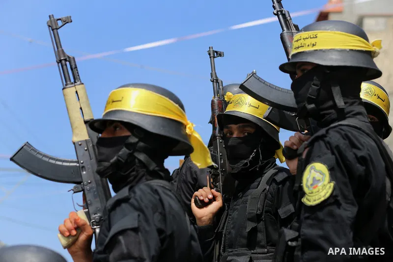 Palestinian militants of Al-Aqsa Martyrs' Brigades attend a funeral of Jihad Abu Jamous who was killed a day earlier during clashes with Israeli security forces in a tent city protest along the Israel border with Gaza, d...