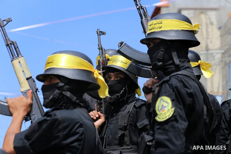 Palestinian militants of Al-Aqsa Martyrs' Brigades attend a funeral of Jihad Abu Jamous who was killed a day earlier during clashes with Israeli security forces in a tent city protest along the Israel border with Gaza, d...
