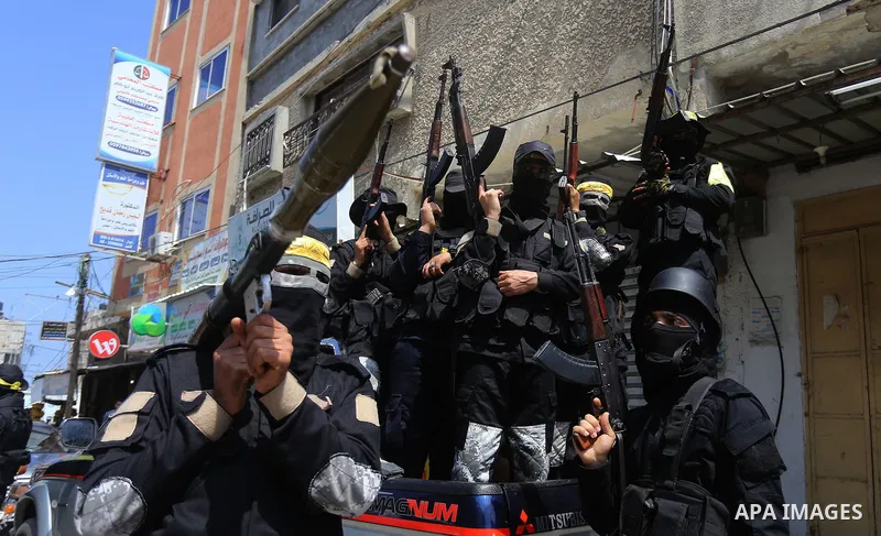 Palestinian militants of Al-Aqsa Martyrs' Brigades attend a funeral of Jihad Abu Jamous who was killed a day earlier during clashes with Israeli security forces in a tent city protest along the Israel border with Gaza, d...