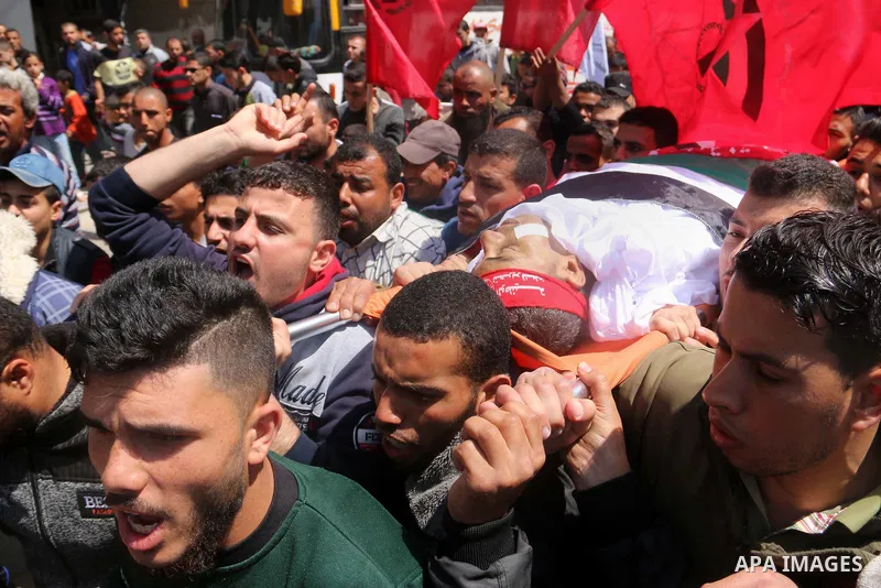 Palestinians carry the body of Abdelkader El Hawajry who was killed a day earlier during clashes with Israeli security forces in a tent city protest along the Israel border with Gaza, demanding the right to return to the...