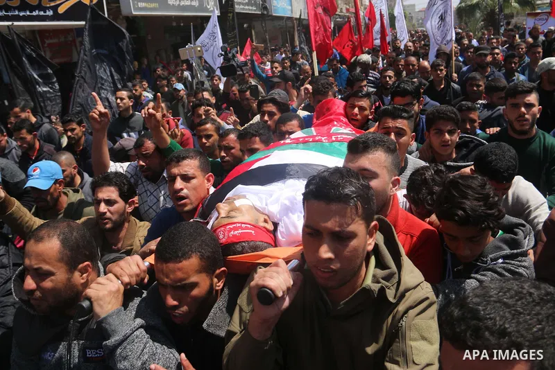 Palestinians carry the body of Abdelkader El Hawajry who was killed a day earlier during clashes with Israeli security forces in a tent city protest along the Israel border with Gaza, demanding the right to return to the...