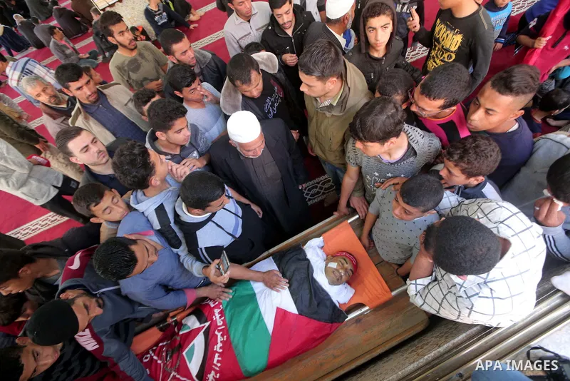 Palestinians carry the body of Abdelkader El Hawajry who was killed a day earlier during clashes with Israeli security forces in a tent city protest along the Israel border with Gaza, demanding the right to return to the...