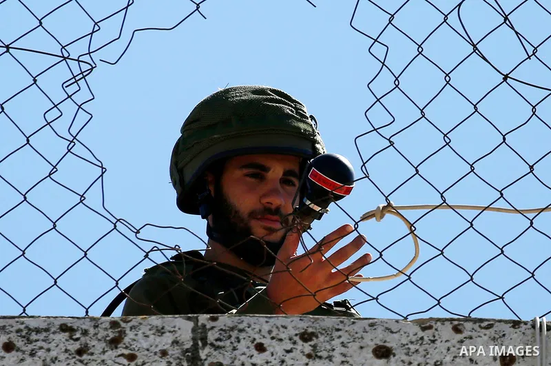 An Israeli soldier throws a tear gas canister during clashes with Palestinian protesters on March 31, 2018 in occupied West Bank city of Hebron as a general strike is called for by local leaders in solidarity with Gaza....