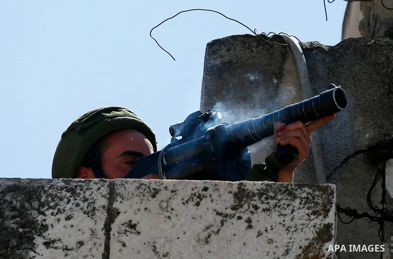 An Israeli soldier throws a tear gas canister during clashes with Palestinian protesters on March 31, 2018 in occupied West Bank city of Hebron as a general strike is called for by local leaders in solidarity with Gaza....