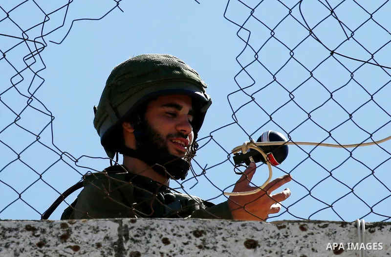 An Israeli soldier throws a tear gas canister during clashes with Palestinian protesters on March 31, 2018 in occupied West Bank city of Hebron as a general strike is called for by local leaders in solidarity with Gaza....