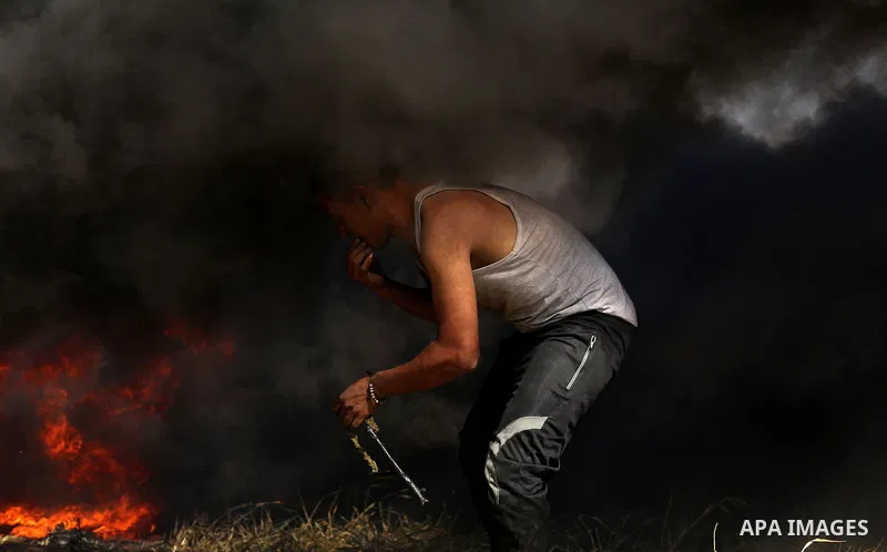 A Palestinian protester hurls stones toward Israeli soldiers during a protest along the border with Israel, east of Khan Yunis, in the southern Gaza Strip on March 31, 2018. The UN Security Council heard fears of a furth...