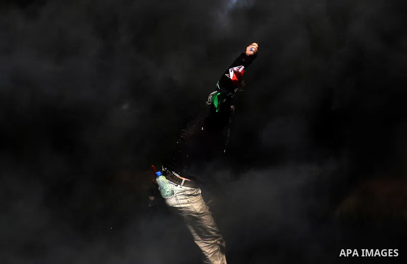 A Palestinian protester hurls stones toward Israeli soldiers during a protest along the border with Israel, east of Khan Yunis, in the southern Gaza Strip on March 31, 2018. The UN Security Council heard fears of a furth...