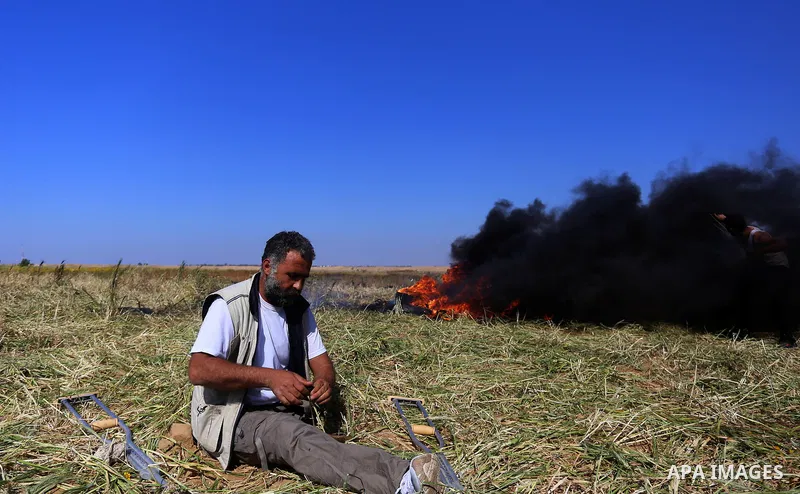 A Palestinian protester hurls stones toward Israeli soldiers during a protest along the border with Israel, east of Khan Yunis, in the southern Gaza Strip on March 31, 2018. The UN Security Council heard fears of a furth...