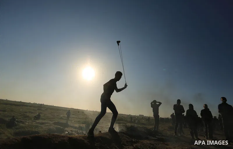 A Palestinian protester hurls stones toward Israeli soldiers during a protest along the border with Israel, east of Gaza City on March 31, 2018. The UN Security Council heard fears of a further escalation in Israeli-Pale...