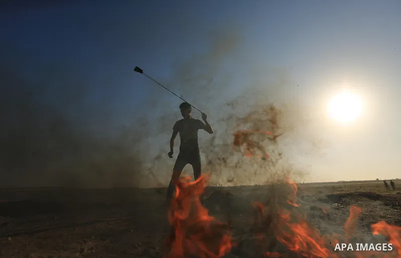 A Palestinian protester hurls stones toward Israeli soldiers during a protest along the border with Israel, east of Gaza City on March 31, 2018. The UN Security Council heard fears of a further escalation in Israeli-Pale...