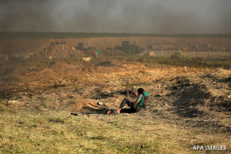 A Palestinian protester hurls stones toward Israeli soldiers during a protest along the border with Israel, east of Gaza City on March 31, 2018. The UN Security Council heard fears of a further escalation in Israeli-Pale...