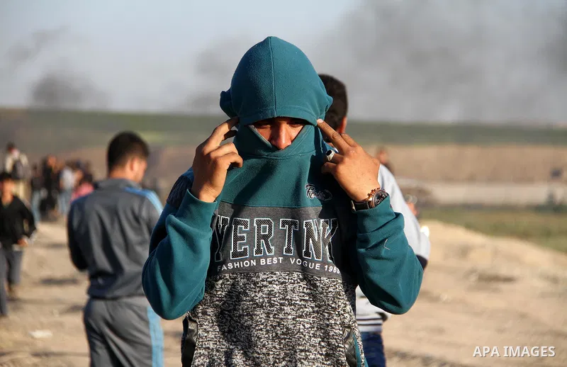 Palestinians react from tear gas, fired by Israeli security forces during clashes in a protest, at the Israel-Gaza border, demanding the right to return to their homeland, east of Gaza City April 1, 2018. Photo by Mahmou...