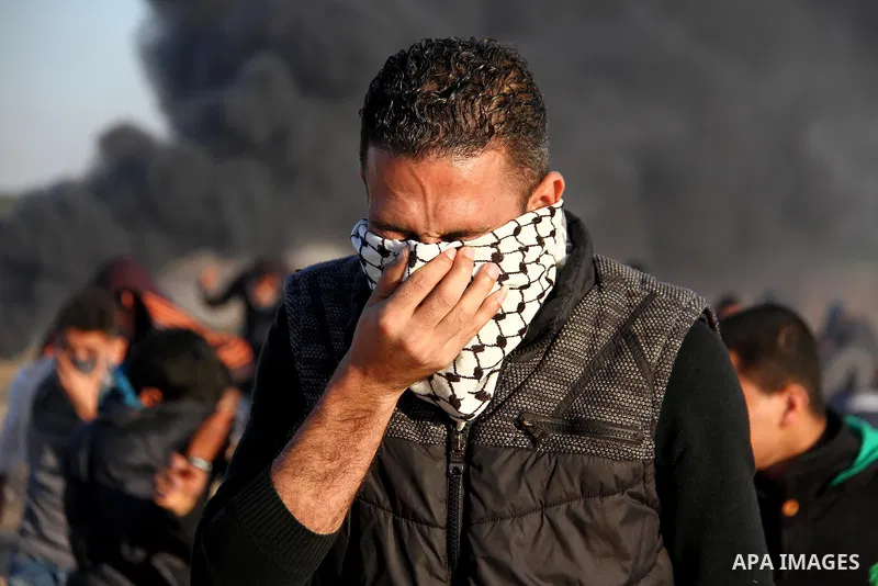 Palestinians react from tear gas, fired by Israeli security forces during clashes in a protest, at the Israel-Gaza border, demanding the right to return to their homeland, east of Gaza City April 1, 2018. Photo by Mahmou...