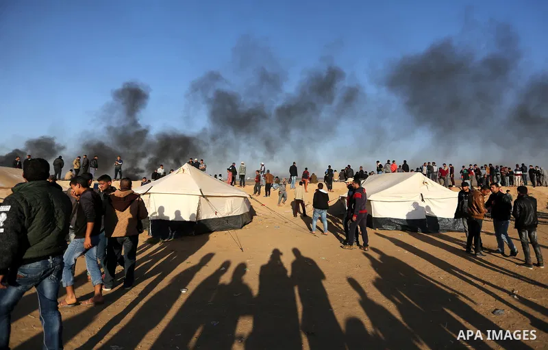 Palestinians sit next to tents during a protest, at the Israel-Gaza border, demanding the right to return to their homeland, in Khan Younis in the southern Gaza strip on April 1, 2018. Photo by Ashraf Amra