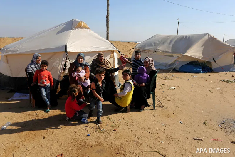 Palestinians sit next to tents during a protest, at the Israel-Gaza border, demanding the right to return to their homeland, in Khan Younis in the southern Gaza strip on April 1, 2018. Photo by Ashraf Amra