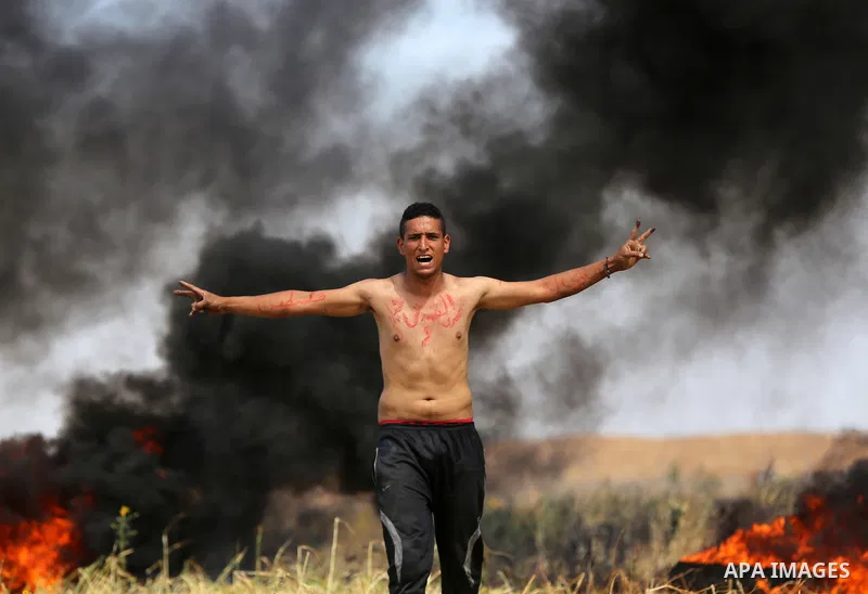 Palestinian protesters demonstrate during clashes with Israeli security forces in a protest, at the Israel-Gaza border during a tent city protest at the Israel-Gaza border, in Khan Yunis in the southern Gaza Strip, on Ap...
