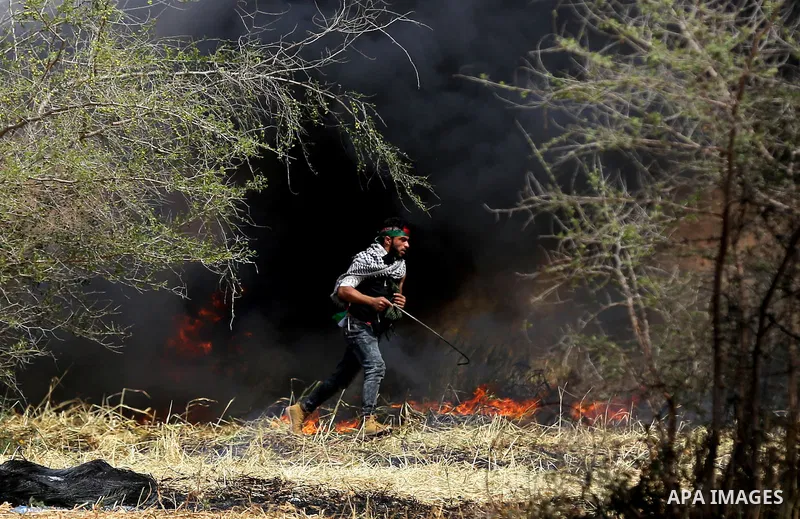Palestinian protesters demonstrate during clashes with Israeli security forces in a protest, at the Israel-Gaza border during a tent city protest at the Israel-Gaza border, in Khan Yunis in the southern Gaza Strip, on Ap...