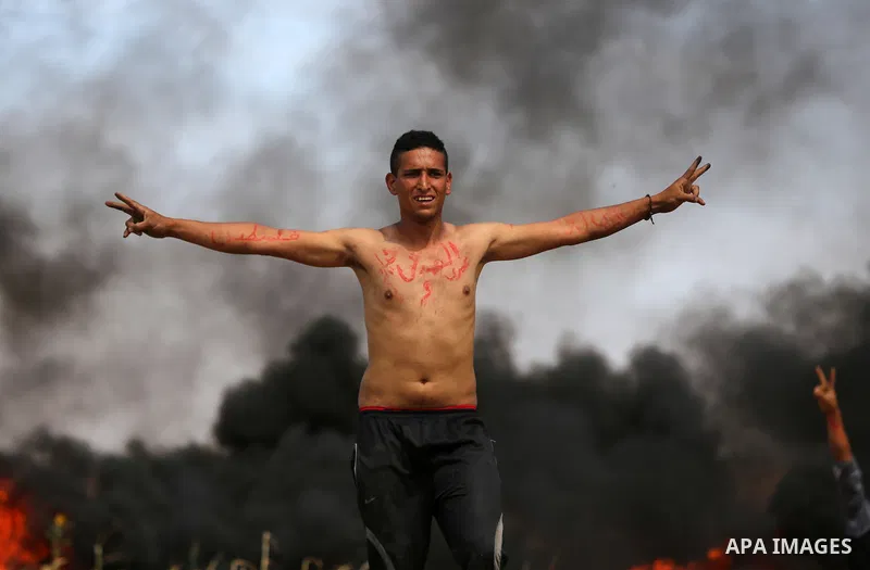 Palestinian protesters demonstrate during clashes with Israeli security forces in a protest, at the Israel-Gaza border during a tent city protest at the Israel-Gaza border, in Khan Yunis in the southern Gaza Strip, on Ap...