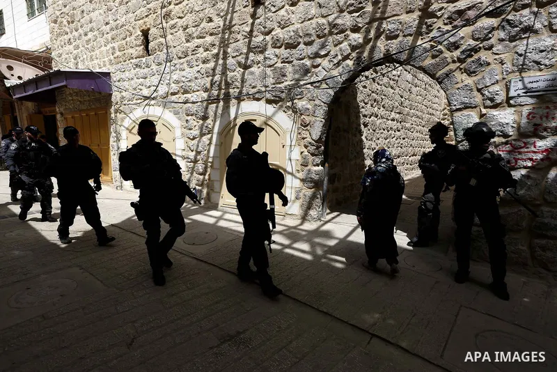 Israeli security forces stand guard as Jewish settlers gather at a Palestinian market in Hebron, in the occupied West Bank April 3, 2018. Photo by Wisam Hashlamoun