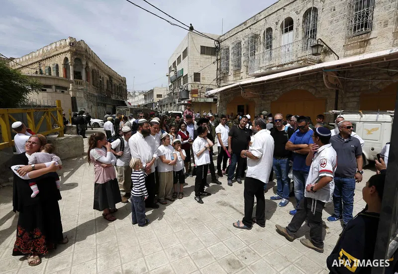 Jewish settlers gather at a Palestinian market in Hebron, in the occupied West Bank April 3, 2018. Photo by Wisam Hashlamoun