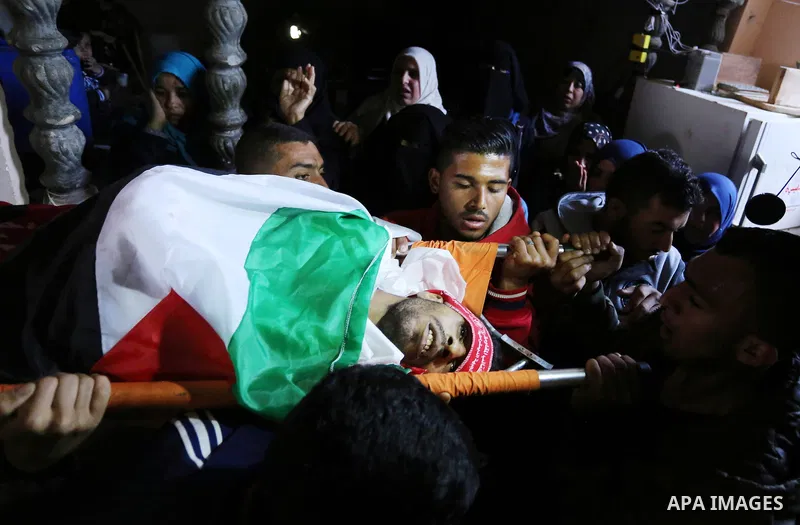 Palestinian mourners carry the body of 25-year-old Ahmed Arafa during his funeral in the city of Deir al-Balah, in the centre of the Gaza Strip on April 4, 2018. Arafa was shot dead by Israeli forces on the Gaza border,...