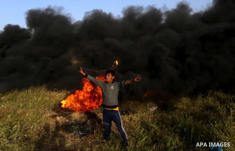 Palestinian protesters react during clashes with Israeli security forces in a tent city protest along the Israel border with Gaza, demanding the right to return to their homeland, in east of Gaza city on April 4, 2018. P...