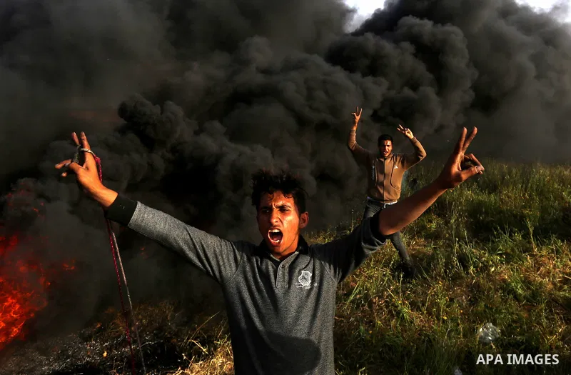 Palestinian protesters react during clashes with Israeli security forces in a tent city protest along the Israel border with Gaza, demanding the right to return to their homeland, in east of Gaza city on April 4, 2018. P...