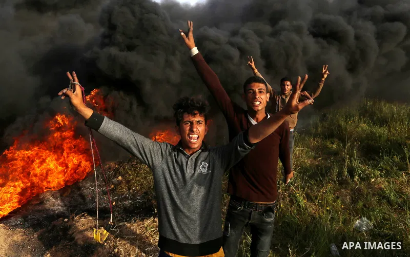Palestinian protesters react during clashes with Israeli security forces in a tent city protest along the Israel border with Gaza, demanding the right to return to their homeland, in east of Gaza city on April 4, 2018. P...