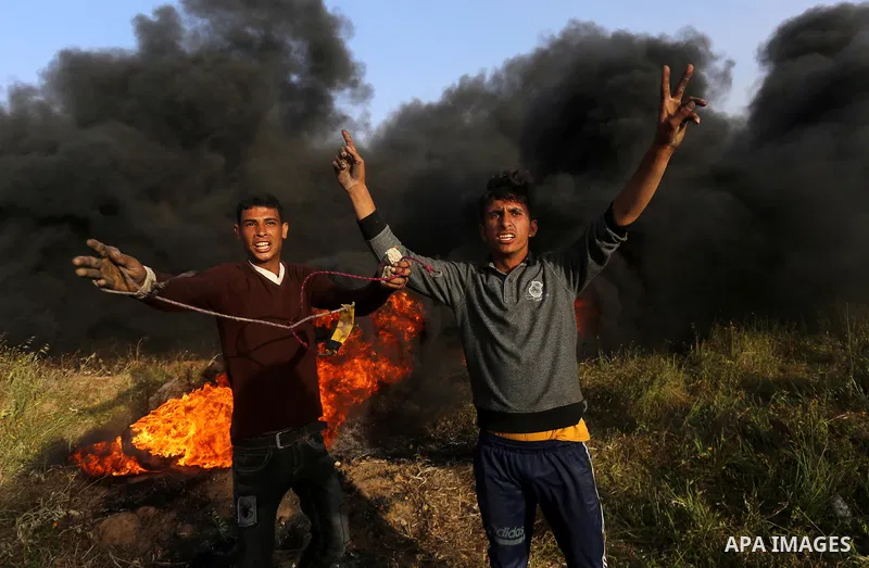 Palestinian protesters react during clashes with Israeli security forces in a tent city protest along the Israel border with Gaza, demanding the right to return to their homeland, in east of Gaza city on April 4, 2018. P...
