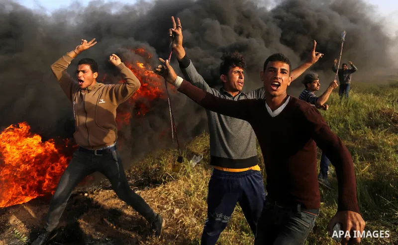 Palestinian protesters react during clashes with Israeli security forces in a tent city protest along the Israel border with Gaza, demanding the right to return to their homeland, in east of Gaza city on April 4, 2018. P...