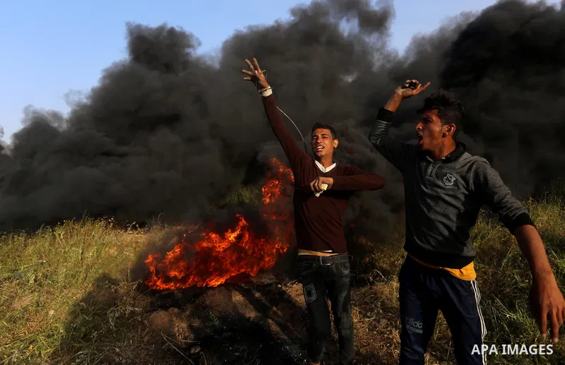Palestinian protesters react during clashes with Israeli security forces in a tent city protest along the Israel border with Gaza, demanding the right to return to their homeland, in east of Gaza city on April 4, 2018. P...