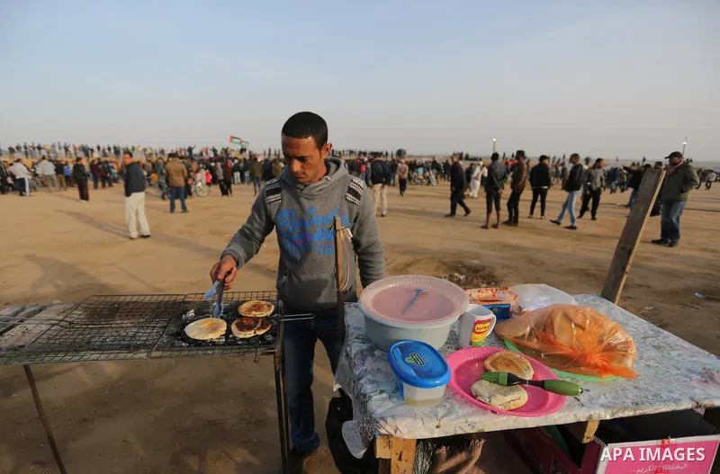 Palestinian men prepare food to protesters during a tent city protest, at the Israel-Gaza border, demanding the right to return to their homeland, in Khan Younis in the southern of Gaza strip on April 4, 2018. Photo by A...