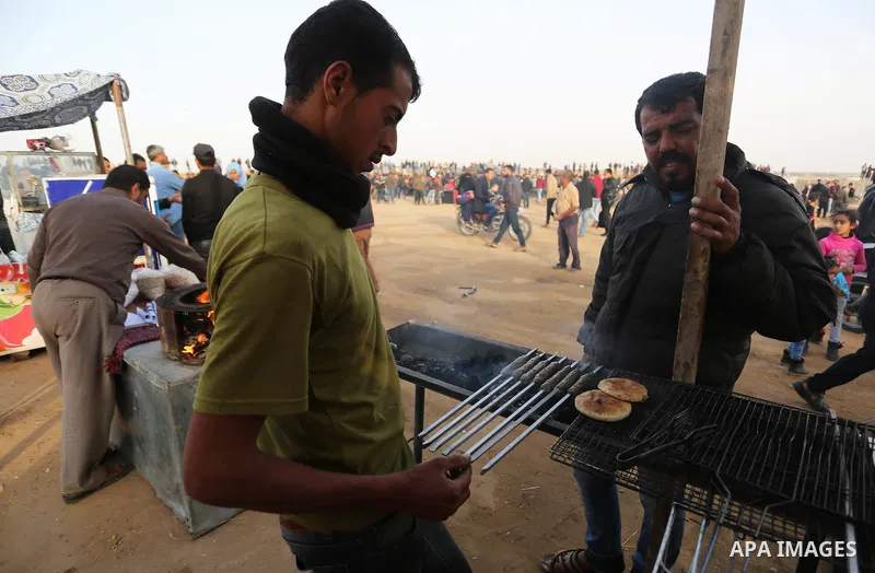 Palestinian men prepare food to protesters during a tent city protest, at the Israel-Gaza border, demanding the right to return to their homeland, in Khan Younis in the southern of Gaza strip on April 4, 2018. Photo by A...
