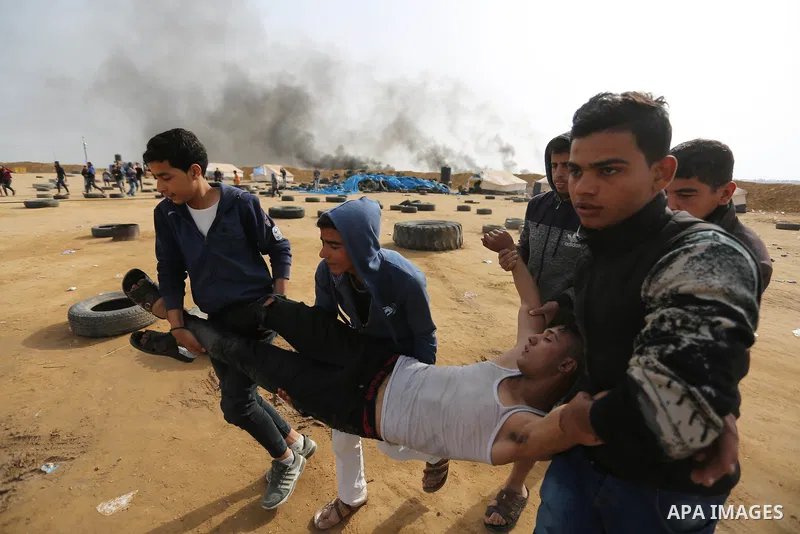 A wounded Palestinian protester is evacuated during clashes with Israeli security forces in a tent city protest at Israel-Gaza border, in the southern Gaza Strip April 5, 2018. Photo by Ashraf Amra