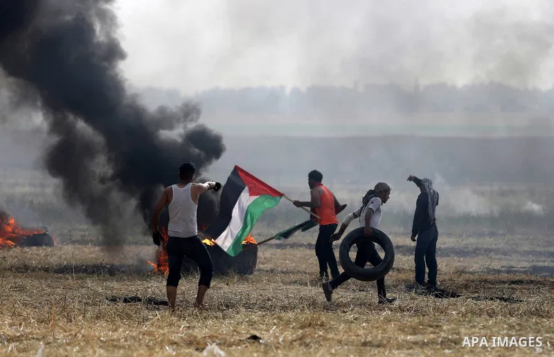 Palestinian protesters react to a tear gas fired by Israeli security forces during clashes in a tent city protest at Israel-Gaza border, in the southern Gaza Strip April 5, 2018. Photo by Ashraf Amra