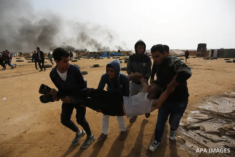A wounded Palestinian protester is evacuated during clashes with Israeli security forces in a tent city protest at Israel-Gaza border, in the southern Gaza Strip April 5, 2018. Photo by Ashraf Amra