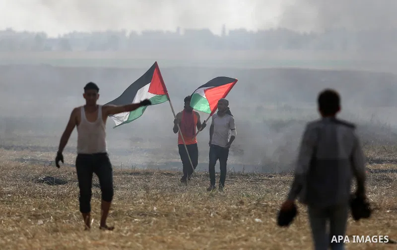 Palestinian protesters react to a tear gas fired by Israeli security forces during clashes in a tent city protest at Israel-Gaza border, in the southern Gaza Strip April 5, 2018. Photo by Ashraf Amra