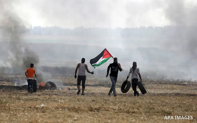 Palestinian protesters react to a tear gas fired by Israeli security forces during clashes in a tent city protest at Israel-Gaza border, in the southern Gaza Strip April 5, 2018. Photo by Ashraf Amra