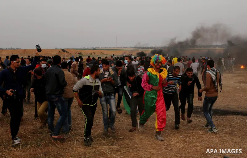 Palestinians wearing costumes are seen at the clashes scene at Israel-Gaza border in the southern Gaza Strip April 5, 2018. Photo by Ashraf Amra
