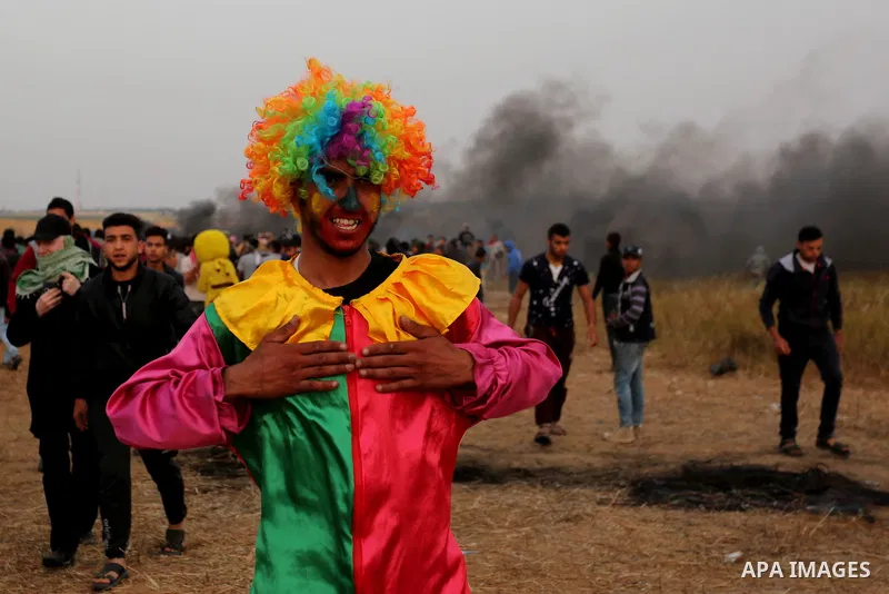 Palestinians wearing costumes are seen at the clashes scene at Israel-Gaza border in the southern Gaza Strip April 5, 2018. Photo by Ashraf Amra