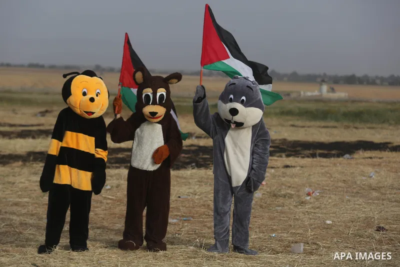 Palestinian protesters react to a tear gas fired by Israeli security forces during clashes in a tent city protest at Israel-Gaza border, in the southern Gaza Strip April 5, 2018. Photo by Ashraf Amra