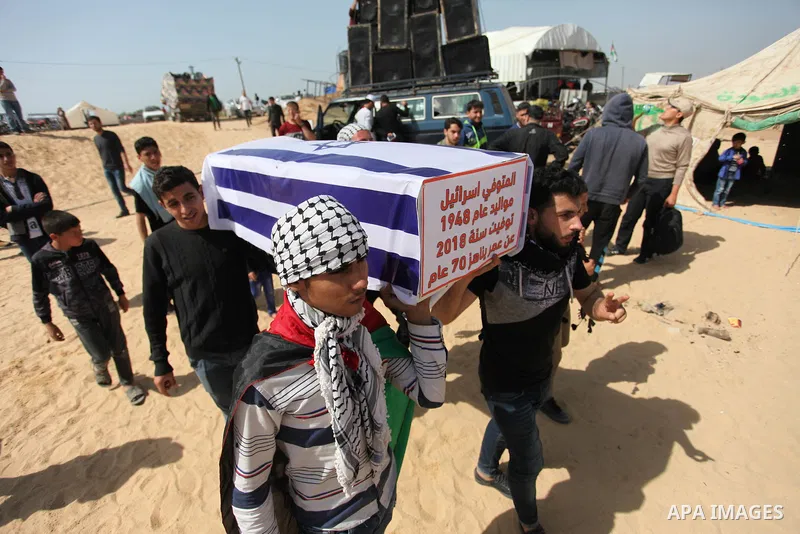 Palestinians children hold a coffin covered with Israeli flag during a tent city protest along the Israel border with Gaza, demanding the right to return to their homeland, in Jabalia in the northern of Gaza strip on Apr...