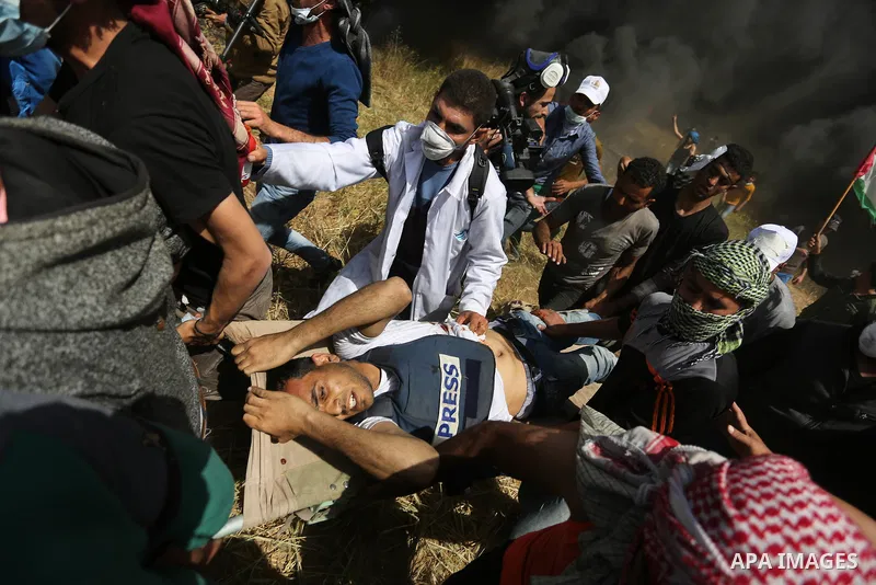 Palestinians evacuate a wounded journalist Yasser Murtaja, 30,during clashes with Israeli security froces in a tent city protest at the Israel-Gaza border, demanding the right to return to their homeland, in Khan Younis...