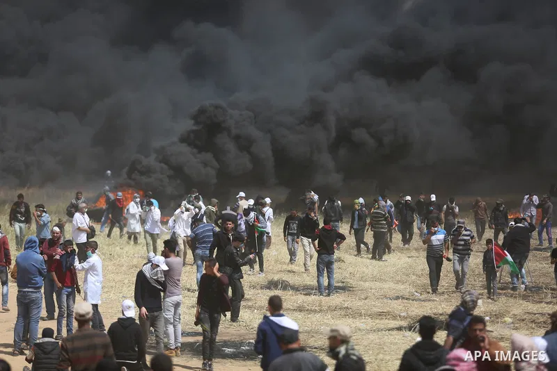 Palestinian protesters burn tires to protect themselves from shots of Israeli soldiers during clashes in a tent city protest at the Israel-Gaza border, demanding the right to return to their homeland, in Khan Younis in t...
