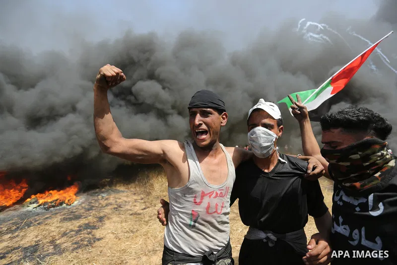 Palestinian protesters burn tires to protect themselves from shots of Israeli soldiers during clashes in a tent city protest at the Israel-Gaza border, demanding the right to return to their homeland, in Khan Younis in t...
